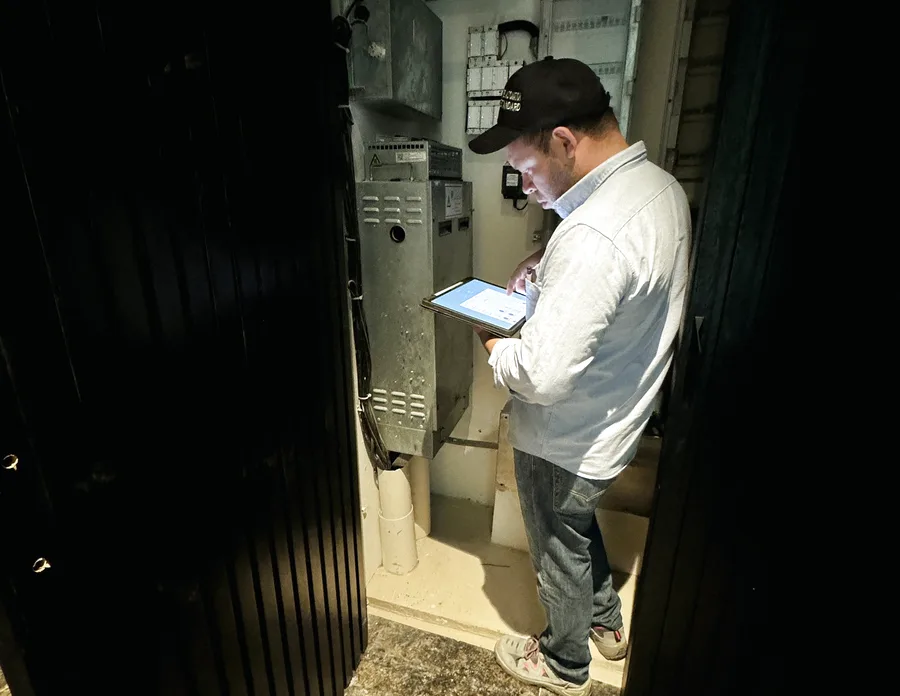 AF DEVS technician commissioning an equipment panel with a tablet